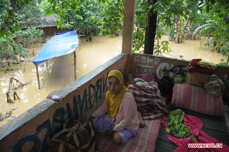  A woman and her ailing husband take shelter on the high ground at the flooded area of Cawang, East Jakarta, Indonesia, March 5, 2013. The National Disaster Mitigation Agency (BNPB) on Tuesday warned that Jakarta could experience another big flood this week, as many areas in the city have already been swamped after the water level at Bogor's Katulampa dam reached 250 centimeters on Monday. (Xinhua/Zulkarnain) 
