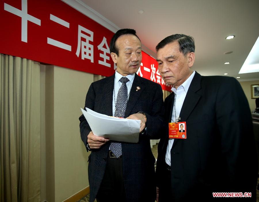 Liu Yiliang (L), a deputy to the 12th National People's Congress (NPC) from the Macao Special Administrative Region, discusses with deputy Yao Hongming on his suggestions in Beijing, capital of China, March 6, 2013. A discussion held by the Macao delegation to the first session of the 12th NPC was open to media on March 6. (Xinhua/Chen Jianli)
