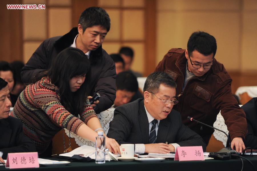 Journalists put voice recorders on the desk where Li Yang (2nd R), a deputy to the 12th National People's Congress (NPC) from east China's Anhui Province, speaks during a discussion in Beijing, capital of China, March 6, 2013. The discussion which was held by the Anhui delegation to the first session of the 12th NPC was open to media on Wednesday. (Xinhua/Du Yu)