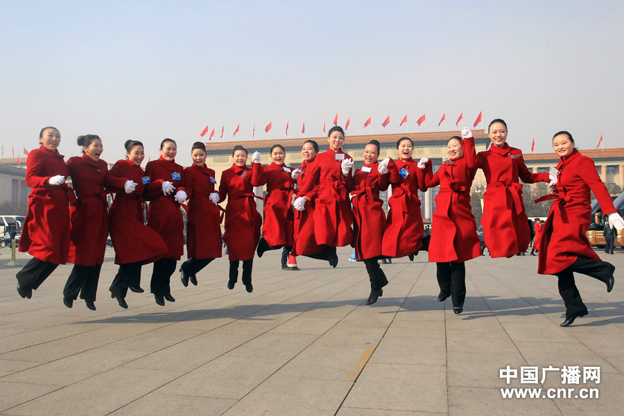 Service staff wearing red uniforms jump up. (Photo/www.cnr.cn) 