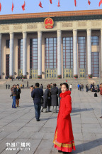A service staff wearing red uniform poses for photos. (Photo/www.cnr.cn)