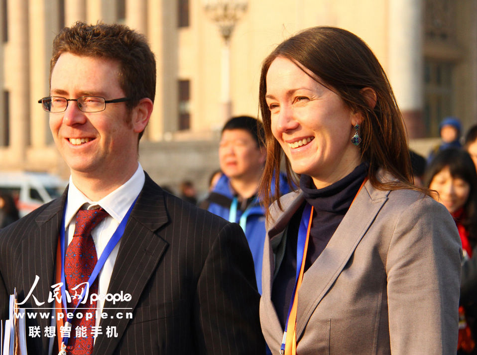 Two foreign reporters keep smiling at a photographer outside the Great Hall of the People during the opening meeting of the first session of the 12th National People's Congress (NPC) in Beijing, capital of China, March 5, 2013. (People’s Daily Online/Yang Fei)