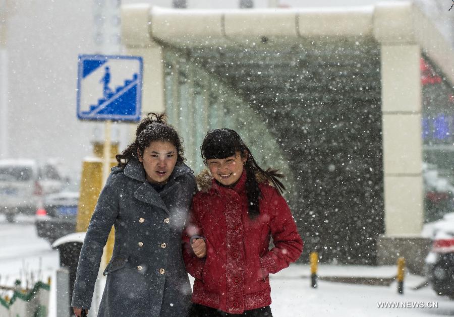 Pedestrians walk on a street amid a spring snow in Urumqi, capital of northwest China's Xinjiang Uygur Autonomous Region, March 8, 2013. (Xinhua/Wang Fei) 