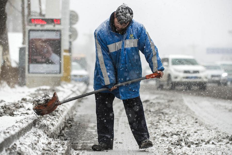A sanitation worker cleans a street amid a spring snow in Urumqi, capital of northwest China's Xinjiang Uygur Autonomous Region, March 8, 2013. (Xinhua/Wang Fei) 