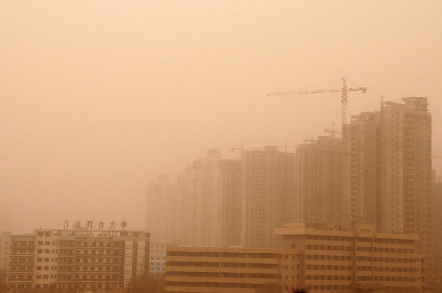 Buildings are blanketed by sand and dust in Lanzhou, capital of northwest China's Gansu Province, March 9, 2013. Sand and dust smothered multiple places in Gansu as a cold front brought strong wind to this region on March 9. (Xinhua/Fan Peishen)