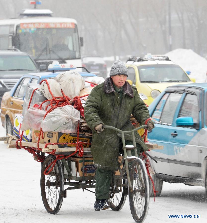 A man rides his tricycle on a snow-covered street in Harbin, capital of northeast China's Heilongjiang Province, March 9, 2013. Local meteorological bureau issued a blue alert against heavy snowfall on Saturday morning. (Xinhua/Wang Song) 