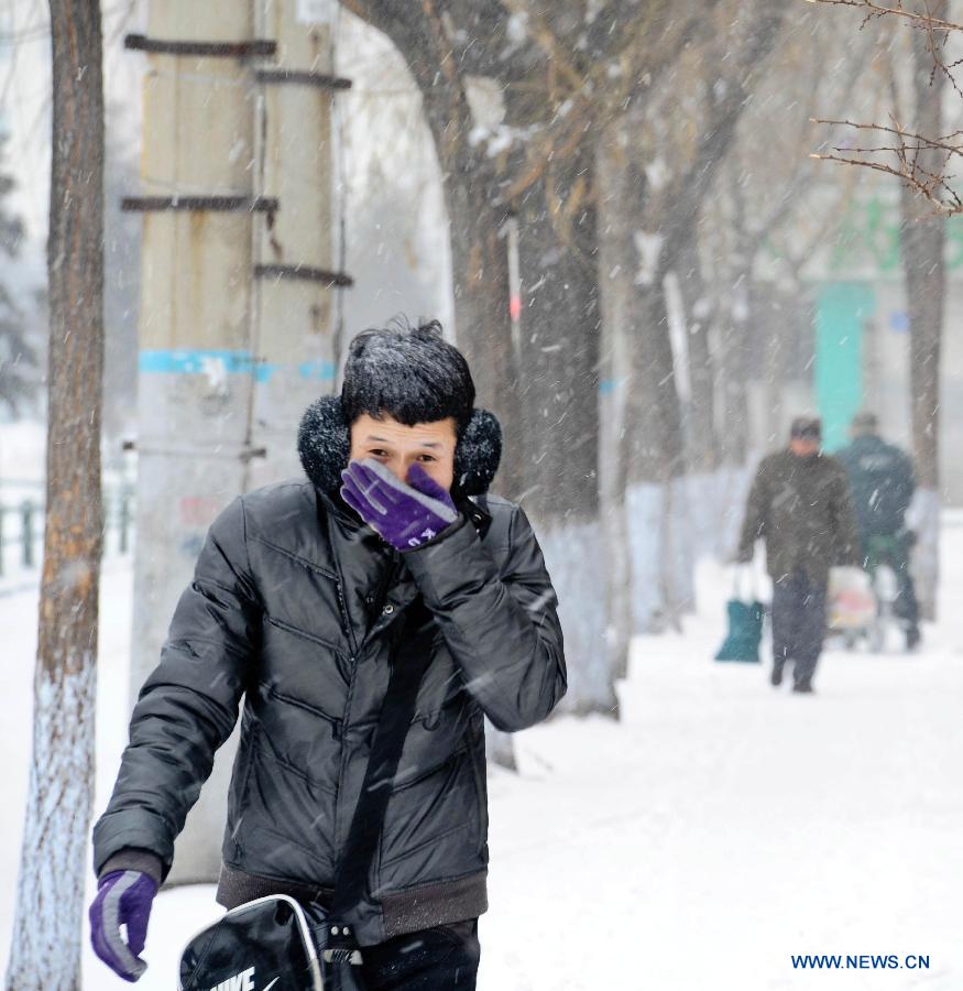 A pedestrian walks on a snow-covered street in Harbin, capital of northeast China's Heilongjiang Province, March 9, 2013. Local meteorological bureau issued a blue alert against heavy snowfall on Saturday morning. (Xinhua/Wang Song)