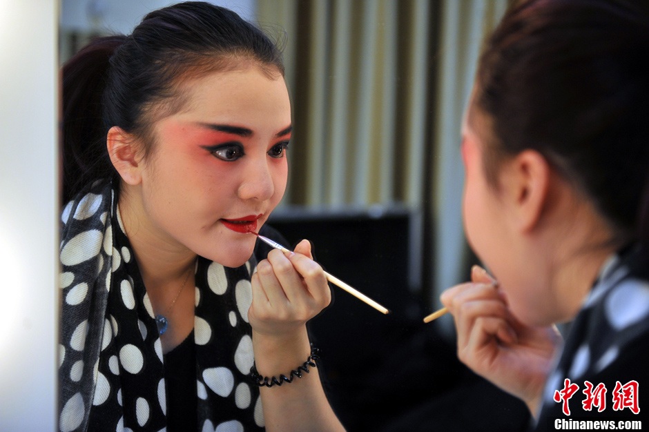 Photo shows the backstage of Gan Opera “Four Dreams in Linchuan”. Female performers are busying putting on make-up and preparing for the performance. (Photo source: chinanews.com)