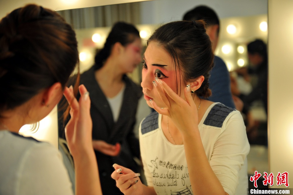 Photo shows the backstage of Gan Opera “Four Dreams in Linchuan”. Female performers are busying putting on make-up and preparing for the performance. (Photo source: chinanews.com)