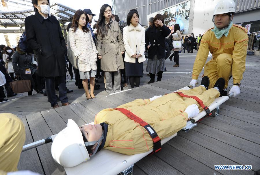 Workers show medical emergency measures during a drill in Tokyo, capital of Japan, on March 11, 2013. A drill to take precautions against natural calamities including medical emergency and fire fighting drills was held here to mark the two year anniversary of the March 11 earthquke and ensuing tsunami that left more than 19,000 people dead or missing and triggered a nuclear accident the world had never seen since 1986. (Xinhua/Kenichiro Seki) 