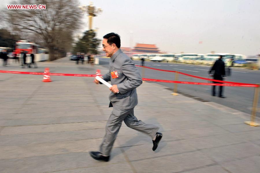 A member of the 12th National Committee of the Chinese People's Political Consultative Conference (CPPCC) runs to the Great Hall of the People after receiving an interview in Beijing, capital of China, March 11, 2013. The fourth plenary meeting of the first session of the 12th CPPCC National Committee is to be held in Beijing on Monday afternoon, at which Chairman, vice-chairpersons, secretary-general and Standing Committee members of the 12th CPPCC National Committee will be elected. (Xinhua/Guo Chen) 