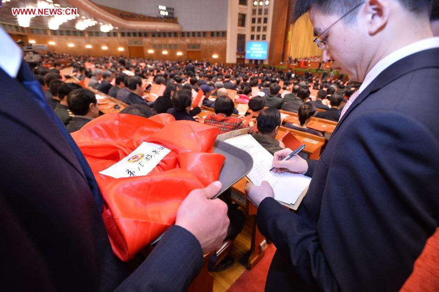 Staff members distribute ballots at the fourth plenary meeting of the first session of the 12th National Committee of the Chinese People's Political Consultative Conference (CPPCC) held at the Great Hall of the People in Beijing, capital of China, March 11, 2013. Chairman, vice-chairpersons, secretary-general and Standing Committee members of the 12th CPPCC National Committee will be elected Monday afternoon. (Xinhua/Wang Ye)