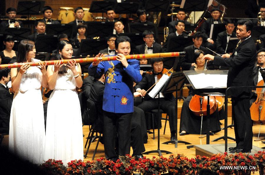 The bamboo flute artist Jiang Guoji (3rd L, front)performs "Jasmine" at Beijing Concert Hall in Beijing, captial of China, March 11, 2013. The Beautiful Emotion concert presented by Zhejiang Symphony Orchestra and the military band of the People's Liberation Army was held here on Monday.(Xinhua/Wang Xiaochuan) 