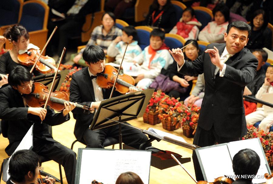 Conductor Zhang Haifeng (1st R) commands musicians at Beijing Concert Hall in Beijing, captial of China, March 11, 2013. The Beautiful Emotion concert presented by Zhejiang Symphony Orchestra and the military band of the People's Liberation Army was held here on Monday.(Xinhua/Wang Xiaochuan) 