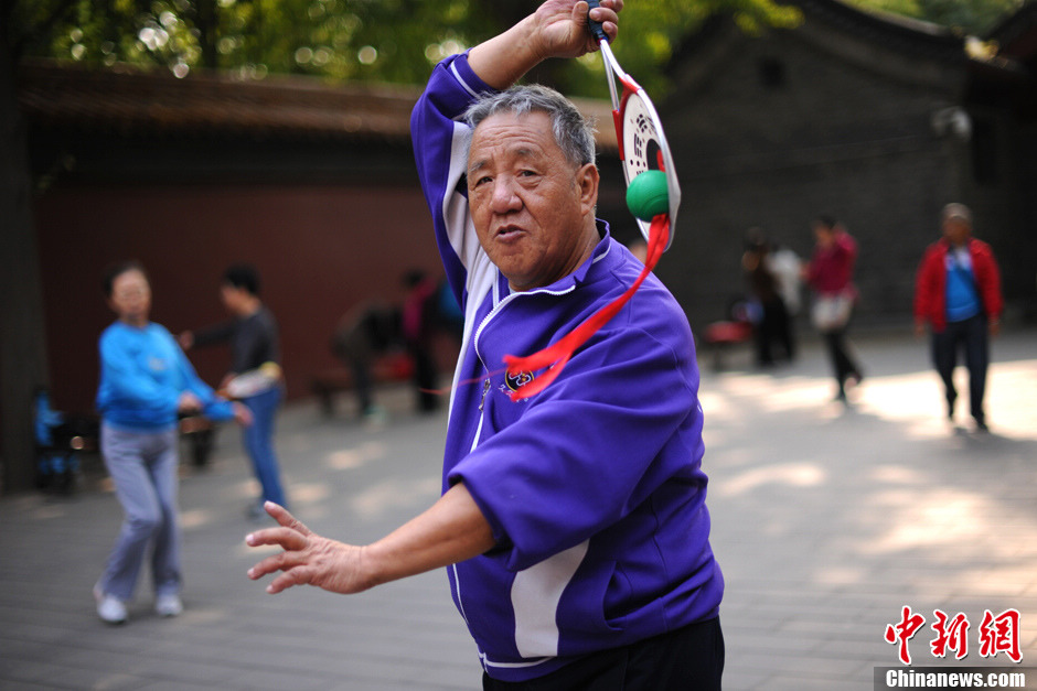 Shi, 72, takes one hour and a half to Jingshan Park by bus every morning. He has taught people the exercise of Rouliqiu for free for five years from 8:30 a.m. to 11 a.m. every morning. Now he has set up the Rouliqiu team in Jingshan Park. His wish is to let more elderly to have a healthy body. (Chinanews/Lin Peiqing)