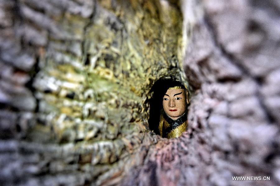 A statue is seen through a small hole in an ancient camphor tree at the Poshi Village in Jianyang City, southeast China's Fujian Province, March 1, 2013. The statue of Zhu Xi (1130-1200), a renowned Chinese ideologist, philosopher and educator during the Southern Song Dynasty (1127-1279), was set inside the 36-meter-high camphor tree. The statue, which is 0.6 meter in height, was initially made at a crack of the tree to commemorate Zhu Xi. Later with the self healing of the crack in the following years, the statue was finally hidden inside the tree and could only be seen through a small hole. (Xinhua/Zhang Guojun) 