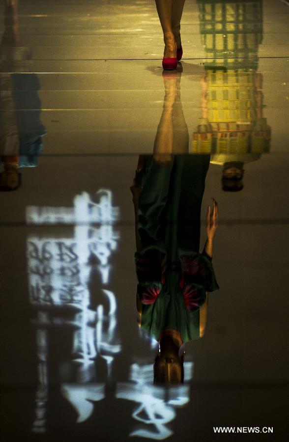 A model presenting a creation of the 2013 graduates of Beijing Institute of Fashion Technology (BIFT) is reflected on a runway at the Institute's 2013 fashion week in Beijing, capital of China, March 12, 2013. The four-day fashion week of BIFT, China's premiere educational facility associated with fashion, kicked off on Tuesday. (Xinhua/Pan Songgang)