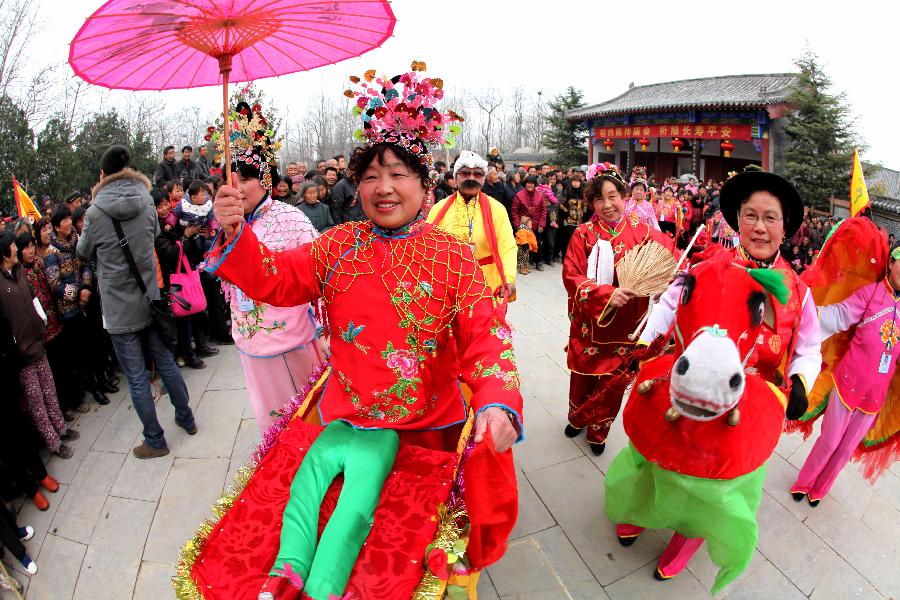 Folk artists perform during a temple fair in celebration of "Er Yue Er" in Bozhou City, east China's Anhui Province, March 13, 2013, on the occasion of the second day of the second lunar month, known in Chinese as Er Yue Er, "a time for the dragon to raise its head", as a Chinese saying goes. Various kinds of traditional activities were held all over the country to celebrate the festival to pray for a good harvest in the coming year. (Xinhua/Liu Qinli)