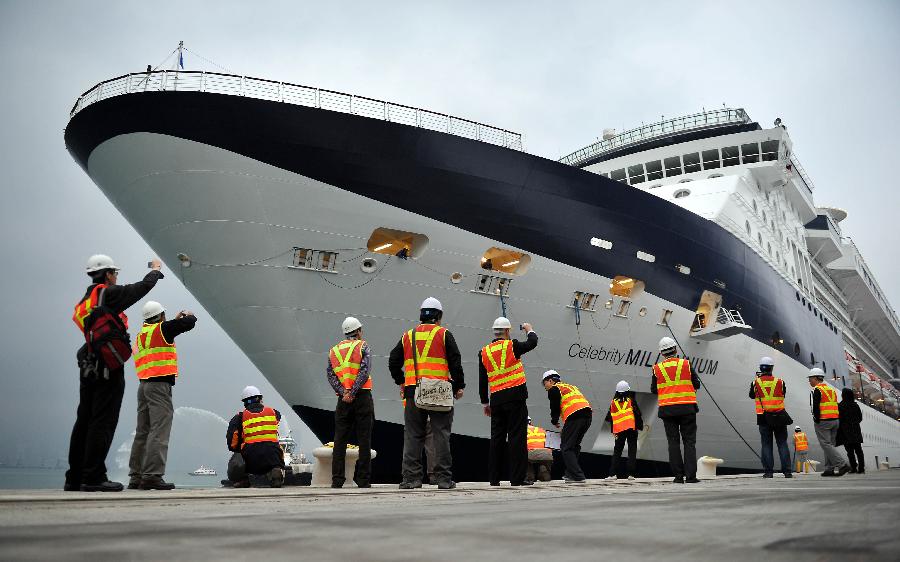 Employees of the Kai Tak Cruise Terminal gather near the cruise ship GTS Millennium in south China's Hong Kong, March 16, 2013. GTS Millennium arrived at Hong Kong's Kai Tak Cruise Terminal on Saturday and became the first cruise ship to berth at the terminal prior to its official opening in June 2013. (Xinhua/Chen Xiaowei) 