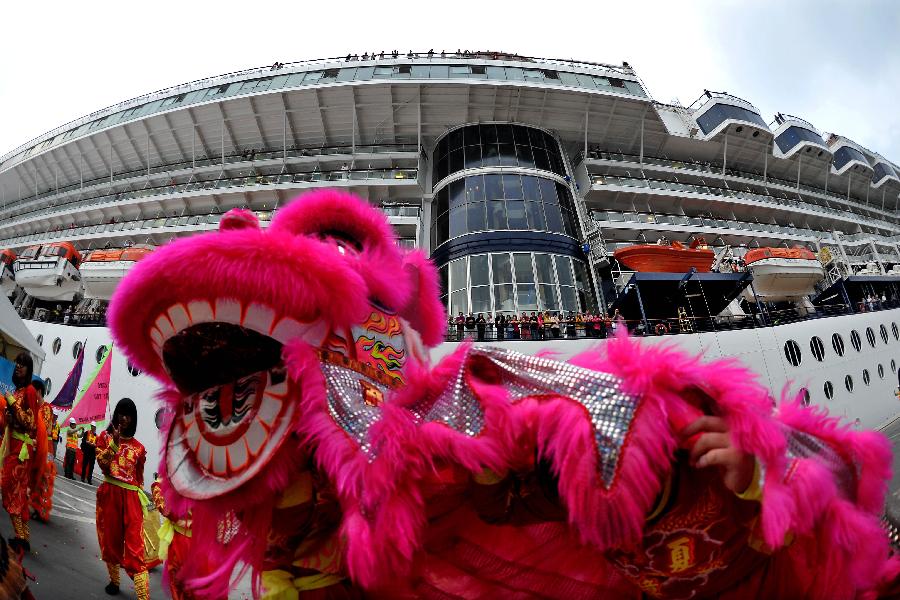 Passengers aboard the cruise ship GTS Millennium watch a lion dance performance at the Kai Tak Cruise Terminal in south China's Hong Kong, March 16, 2013. GTS Millennium arrived at Hong Kong's Kai Tak Cruise Terminal on Saturday and became the first cruise ship to berth at the terminal prior to its official opening in June 2013. (Xinhua/Chen Xiaowei) 