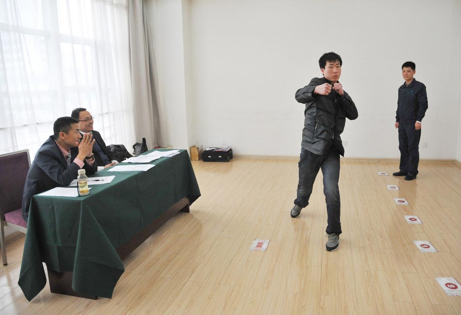 A candidate shows fighting skills for a test held to recruit flight security officers for Hainan Airlines, China's fourth largest airline, Taiyuan, northern China's Shanxi province on March 16, 2013. The airlines favored applicants who are graduates from military or police school or veterans. Besides appearance, applicants' manners, psychological quality in the interview, fighting skills and physical strength are also examined, which are essentials for flight security officers to deal with any emergent matter and security threat immediately.  (Photo/ Imagine China )   