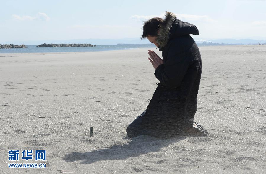 A man prays for his friend who was killed by the tsunami at Arahama district in Sendai. Japan last Monday marked the second anniversary of the ferocious tsunami that claimed nearly 19,000 lives and sparked the worst nuclear accident in a generation. (Xinhua /AFP)