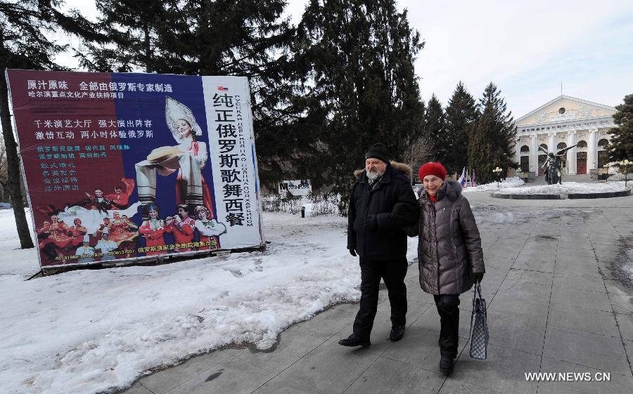 Eremin Sergei and his mother walk past the Russia Royal Theater on the Sun Island in Harbin, capital of northeast China's Heilongjiang Province, March 15, 2013.(Xinhua/Wang Jianwei) 