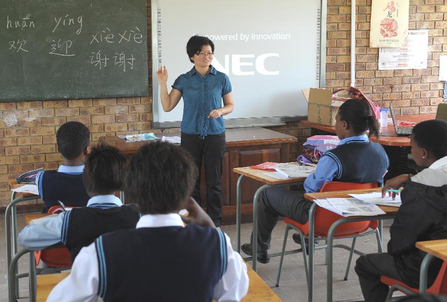 Shaodan, a Chinese teacher of Confucius Institute, teaches Chinese at a secondary school, 40 km east of Pretoria, South Africa, Feb. 25, 2013. In recent years, Africa has witnessed a growing passion for the Chinese language and increasing requests to set up Chinese teaching institutions. To cater to this growing need, China opened the Confucius Institute at the University of Nairobi in 2005, the first of its kind in Africa. The latest figure shows that there are 31 Confucius Institutes and 5 Confucius Classrooms in Africa as of September 2012. (Xinhua/Li Qihua)