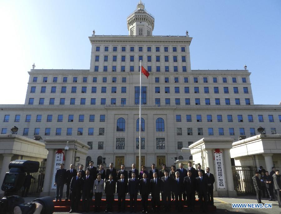 Staff members of the newly-merged State General Administration of Press, Publication, Radio, Film and Television pose for group photos during a ceremony to hang the new nameplate in Beijing, capital of China, March 22, 2013. China's National People's Congress, the country's top legislature, has adopted a cabinet reshuffle plan in which two media regulators, the General Administration of Press and Publication and the State Administration of Radio, Film and Television, were merged into a single entity to oversee the country's press, publication, radio, film and television sectors. (Xinhua/Wang Zhen)