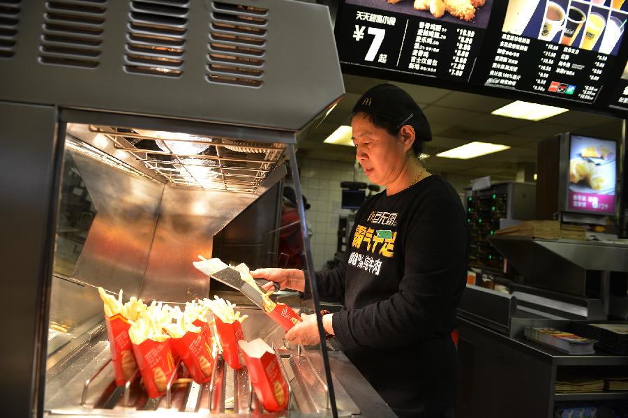 53-year-old Kang Jiangfeng prepares chips at the McDonald's restaurant at Chang'an Market, where she has worked for 19 years since 1994, in Beijing, capital of China, March 24, 2013. Opened in 1993 as the second outlet of the American fast-food giant in Beijing, the Chang'an Market McDonald's made indelible impressions on locals. Due to reconstruction and adjustment of the market, the outlet discontinued its business Sunday. (Xinhua/Li Xin)