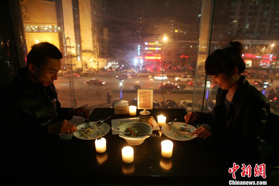 People enjoy a candlelight dinner in a restaurant in Taiyuan, Shanxi on March 23, 2013. The restaurant lit candles instead of lamps on each dining table to mark Earth Hour. (CNS/Zhang Yun)