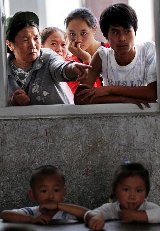 On Sep. 1, 2009, the first day of the new semester, many parents are waiting outside the first grade's classrooms of Lantian Primary School, a school for migrant workers' children. Their eyes meticulously follow each and every move of their children. (Zhejiang Daily/Chu Yongzhi)