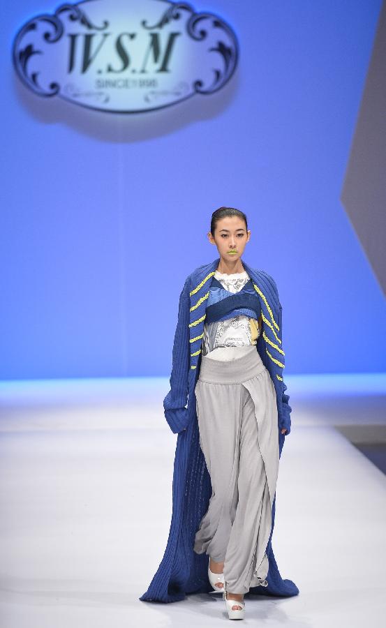 A model presents a creation in the WSM China Knitwear Fashion Design Contest 2013 during the China Fashion Week in Beijing, capital of China, March 26, 2013. The design by Sheng Lina from Fashion School & Engineering of Zhejiang Sci-Tech University won the championship of the contest. (Xinhua/Li Xin) 