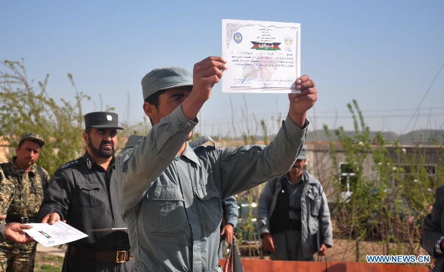 A Afghan newly graduated policeman holds his certification during the graduation ceremony in Sari Pul province in northern Afghanistan on March 28, 2013.A total of 33 Afghan policemen graduated on Thursday after two-month training in Sari Pul province, police officials said. (Xinhua/Arui)