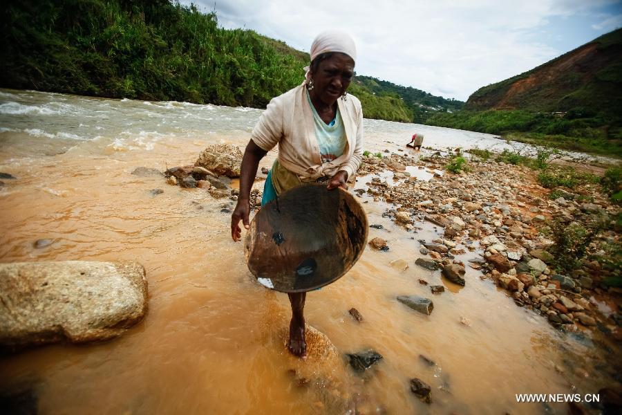 A woman works searching for gold at the municipality of Suarez, in Cauca, Colombia, on March 27, 2013. Suarez is known for its gold deposits and mines. Around 80 percent of its population works searching for gold, despite the ongoing dispute with multinational companies and groups operating outside the law. (Xinhua/Jhon Paz) 