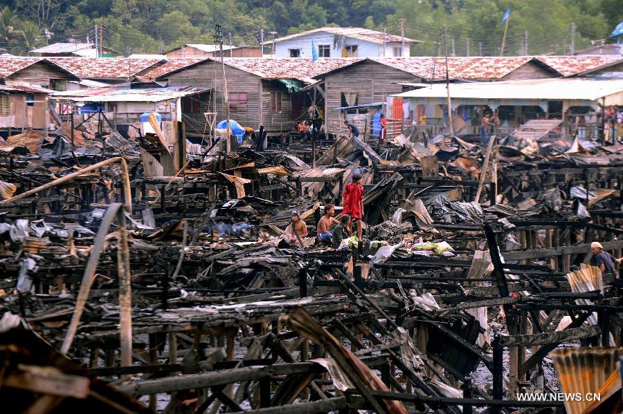 Remains of the wooden houses are seen after a fire in Kota Kinabalu, Malaysia, March 28, 2013. A fire engulfed over 400 wooden houses on the sea on Wednesday, leaving more than 3,000 people homeless and dozens injured. (Xinhua) 