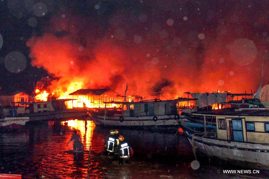 Fire fighters try to put out a fire in Kota Kinabalu, Malaysia, March 27, 2013. A fire engulfed over 400 wooden houses on the sea on Wednesday, leaving more than 3,000 people homeless and dozens injured. (Xinhua) 