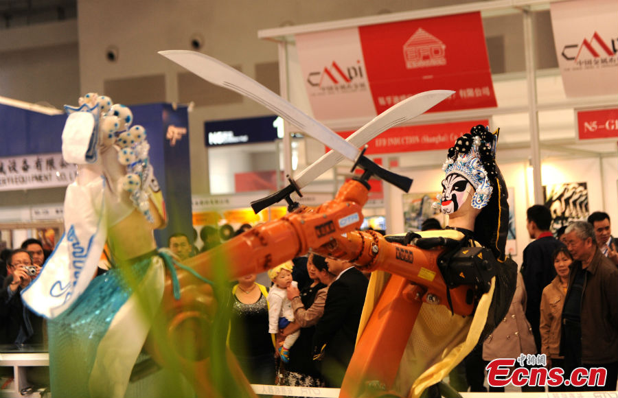 Robots clad in Peking Opera costumes display their technical ability at the13th China Metal and Metallurgy Exhibition in Chongqing, March 28, 2013. (CNS/Chen Chao)