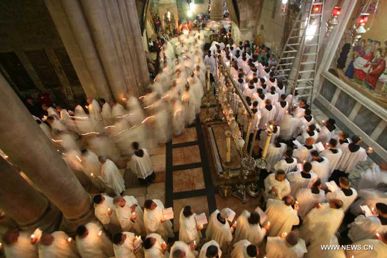 Members of the Catholic clergy hold candles as they take part in a procession at the Catholic Washing of the Feet ceremony in the Church of the Holy Sepulchre in Jerusalem's Old City during Holy Week on March 28, 2013. Holy Week is celebrated in many Christian traditions during the week before Easter. [Photo:Xinhua/Muammar Awad]