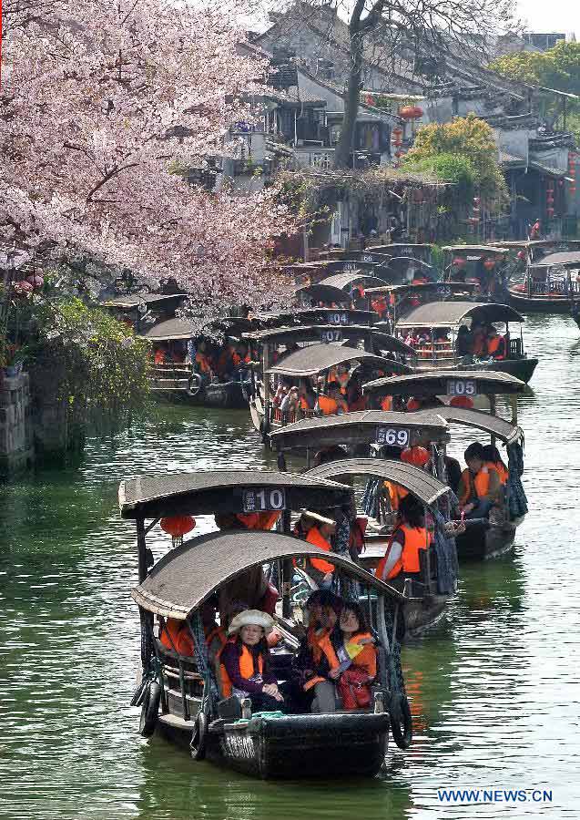 Visitors take boats while touring in the Xitang Township of Jiaxing City in east China's Zhejiang Province, March 30, 2013. Xitang, a township which enjoys thousand years' history, embraced large numbers of visitors recently. (Xinhua/Wang Song)