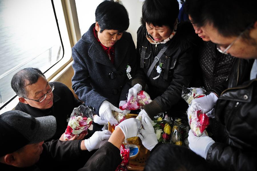 Citizens put petals in a bag with ashes of their deceased relative before scattering the ashes in the sea at a sea burial in Tianjin, north China, March 31, 2013, ahead of the Qingming Festival, or Tomb Sweeping Day, which falls on April 4 this year. (Xinhua/Zhang Chaoqun) 