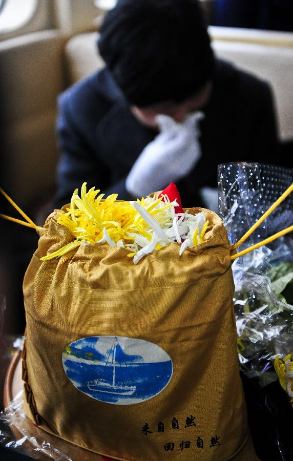 Petals and ashes are put in a bag before being scattered in the sea at a sea burial in Tianjin, north China, March 31, 2013, ahead of the Qingming Festival, or Tomb Sweeping Day, which falls on April 4 this year. (Xinhua/Zhang Chaoqun) 