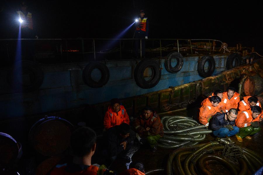 Photo taken on March 29, 2013 shows police watching over smugglers on a boat offshore east China's Zhejiang Province. A gangs smuggling case involving 15,000 tons of refined oil worthy over 100 million Yuan (approximately 15.9 million U.S. dollars) was seized here on Sunday, as announced by Hangzhou customs on March 31, it is the biggest ever gangs smuggling case offshore Zhejiang province. (Xinhua/Xu Yu)