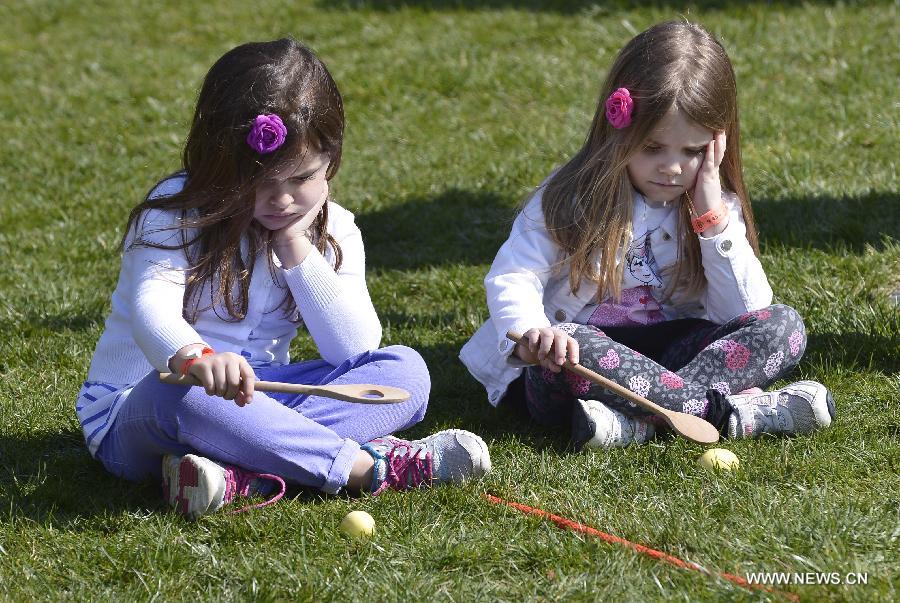 Two young sisters participate in the annual White House Easter Egg Roll on the South Lawn of the White House in Washington D.C., capital of the United States, April 1, 2013. U.S. President Barack Obama hosted the annual celebration of Easter on Monday, featuring Easter egg roll, live music, sports, cooking and storytelling. (Xinhua/Zhang Jun) 