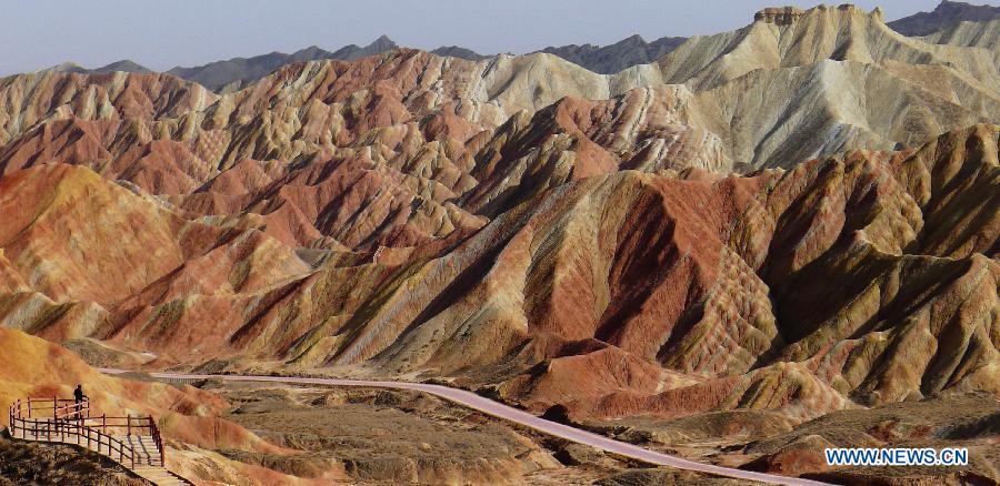 A visitor views the Danxia Landform in Zhangye City, northwest China's Gansu Province, April 1, 2013. Danxia is a special landform from reddish sandstone that has been eroded over time into a series of mountains surrounded by curvaceous cliffs and many unusual rock formations. (Xinhua/Shi Youdong)