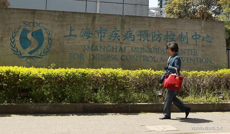 A citizen passes by the Shanghai Municipality Centre for Disease Control & Prevention in Shanghai, east China, April 3, 2013. The city government launched a third-level contingency plan for flu prevention and control on Tuesday. By far, no new case of pneumonia caused by unknown reasons has been reported. (Xinhua/Ding Ding)