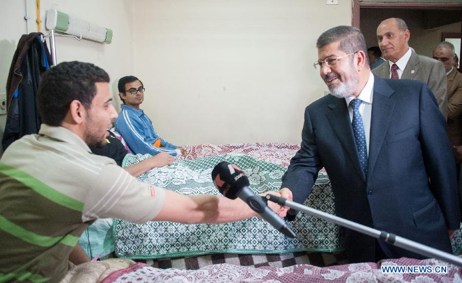 Egyptian President Mohamed Morsi (front R) visits al-Azhar University students who suffered food poisoning at a hospital in Cairo, Egypt, Apr. 2, 2013. As many as 561 Egyptian students of al-Azhar University have been infected with food poisoning on Apr, 1, with no deaths reported, spokesman for the Ministry of Health Yahia Moussa told Xinhua on Tuesday. (Xinhua/Qin Haishi) 