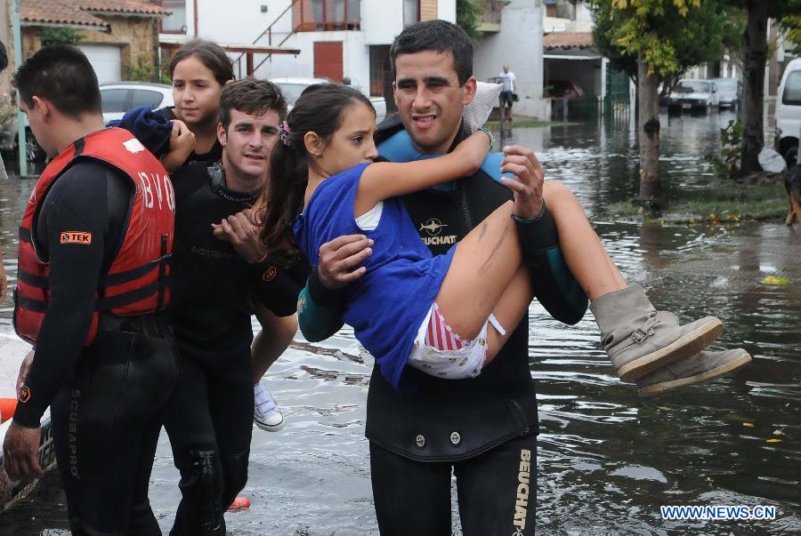 Two girls are evacuated at a flooded area after a storm, in Tolosa, La Plata, 63 km south of Buenos Aires, Argentina, on April 3, 2013. At least 46 people have died due to heavy storms in La Plata, and another 3,000 have been evacuated. (Xinhua/TELAM) 