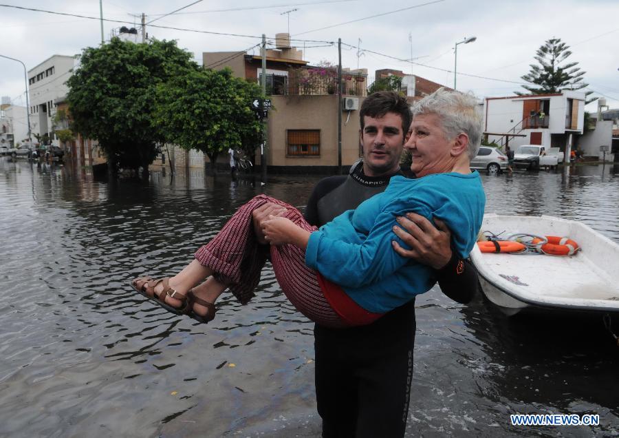 A local resident is evacuated at a flooded area after a storm, in Tolosa, La Plata, 63 km south of Buenos Aires, Argentina, on April 3, 2013. At least 46 people have died due to heavy storms in La Plata, and another 3,000 have been evacuated. (Xinhua/TELAM) 