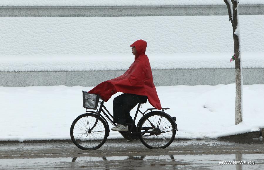 A local resident rides in snow in Chaoyang City, northeast China's Liaoning Province, April 5, 2013. While many parts of China have entered a blossoming season, Chaoyang experienced a heavy snowfall on Friday. (Xinhua/Qiu Yijun)